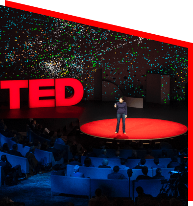 TEDx stage with a speaker and audience